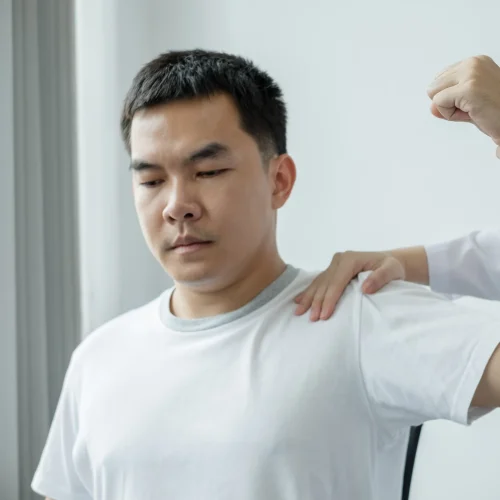 Massage therapist applying joint mobilization to a client’s shoulder and spine
